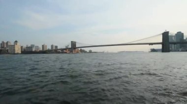Arka plan New York'ta Brooklyn köprüsü ile küçük dalgalar halinde hareket sakin okyanus suyu hızlı düşük açı zaman atlamalı görünümü