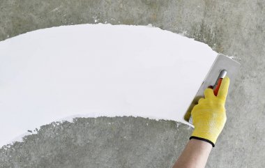 Bir spatula ile el, macun katmanı uygulama süreci. Dairelerin tadilatı. Duvarları onar. Reklam ve metin için boş alan.