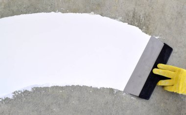 Bir spatula ile el, macun katmanı uygulama süreci. Dairelerin tadilatı. Duvarları onar. Reklam ve metin için boş alan.