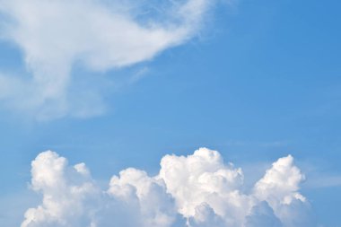 Güneşli bir yaz gününde mavi bir arka plan üzerinde güzel beyaz bulutlar. Metin için boş alan. Tasarımcı için arka plan.