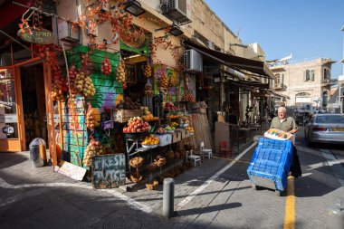 Tel-Aviv / İsrail - Kasım 2017: adamın biri girer Carmel Pazarı meyve dükkanında yakınındaki kasaları ile