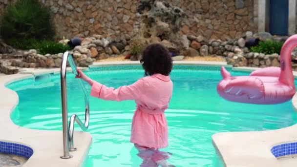 Hermosa modelo posa hasta la cintura en el agua sale de la piscina — Vídeo de stock