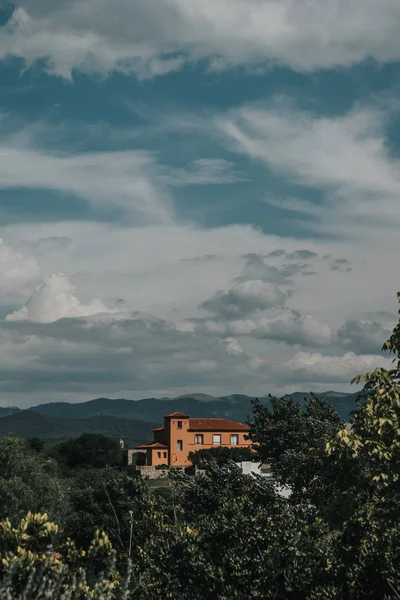Manzara dağın tepesinde bir kır evi.