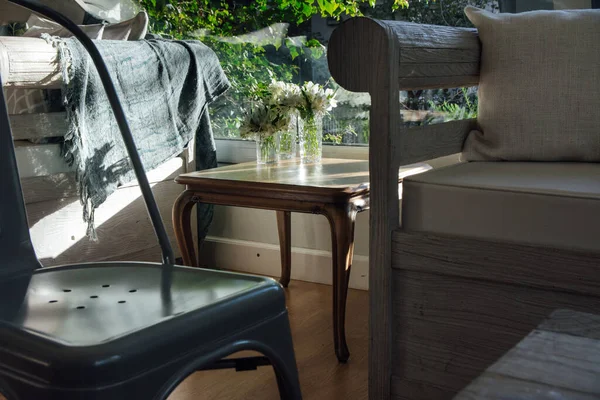 Cam vazolarlı ahşap masa, kırsal ahşap koltuk ve metal sandalyeler..