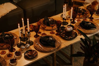 Mumlarla, gözlüklerle ve dekorasyonlarla dolu Noel masası.