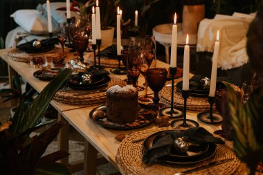 Mumlarla, gözlüklerle ve dekorasyonlarla dolu Noel masası.