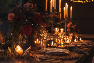 Mumlar, çiçekler ve bardaklarla dolu Noel masası