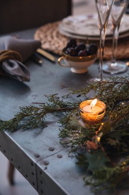 Noel masasında mumlar, çiçekler ve meyveler