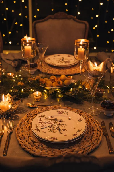 Mumlar, çiçekler ve bardaklarla dolu Noel masası