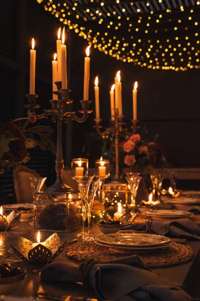 Mumlar, çiçekler ve bardaklarla dolu Noel masası