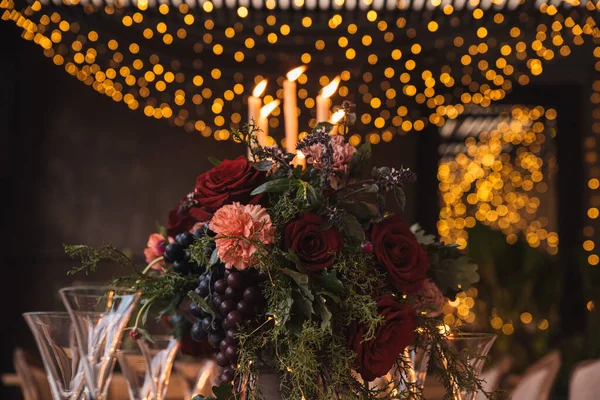 Noel masasında mumlar, çiçekler ve meyveler