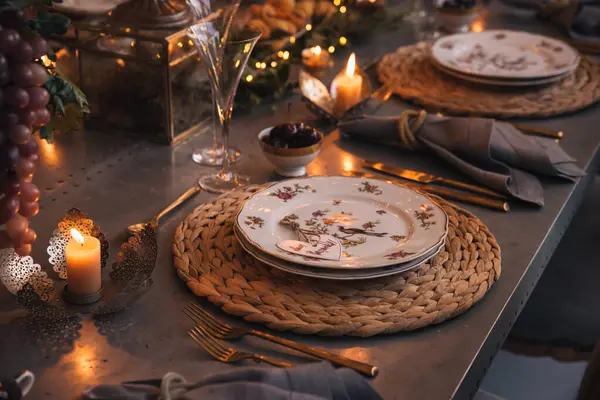 Mumlar, çiçekler ve cam bardaklarla dolu Noel masası..