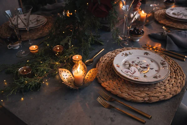 Mumlar, çiçekler ve cam bardaklarla dolu Noel masası..