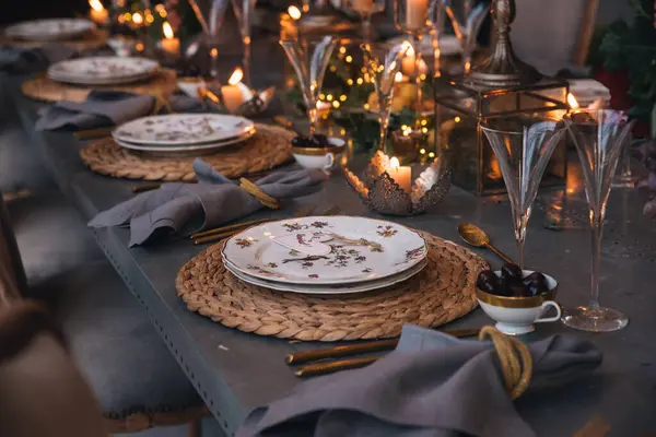 Mumlar, çiçekler ve cam bardaklarla dolu Noel masası..