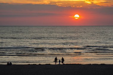Gün batımı saatinde Evening Beach'te aile