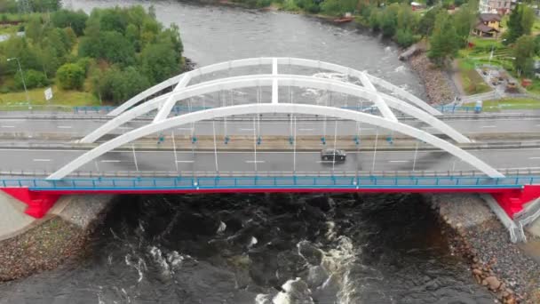 Lucht video van de gewelfde brug met auto's aan de overkant van de rivier — Stockvideo