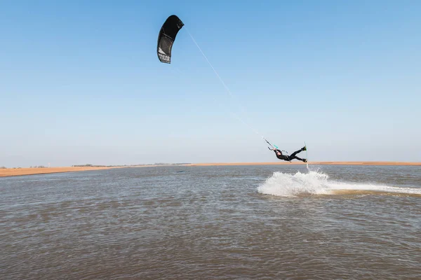 Kiteboarder pulling tricks and getting air on a bright summers day with perfect clear blue sky\'s. Shingle Strret, Suffolk, UKKiteboarder pulling tricks and getting air on a bright summers day with per