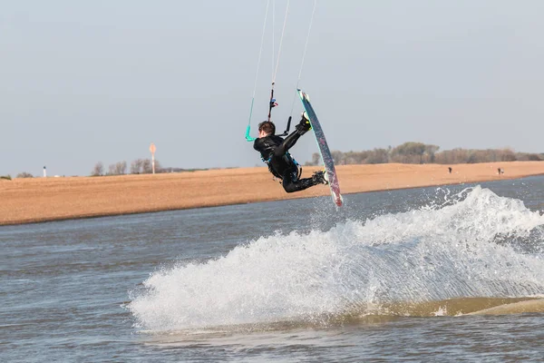 Kiteboarder pulling tricks and getting air on a bright summers day with perfect clear blue sky\'s. Shingle Strret, Suffolk, UK