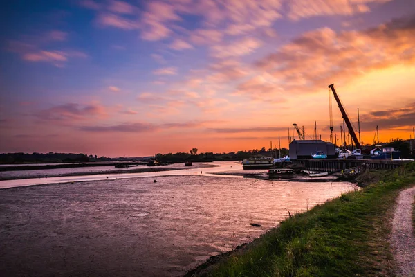 Sonnenuntergangsbild am Ufer des Flusses deben mit Schmelzbootswerft im Hintergrund — Stockfoto