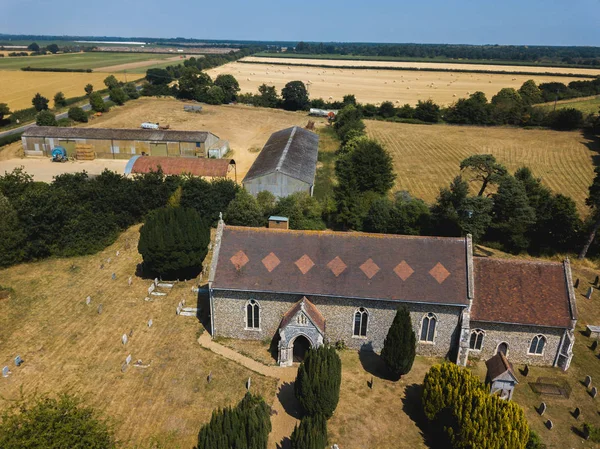 Uma vista aérea da igreja de Todos os Santos em Sutton com uma fazenda e campos de fazenda no fundo — Fotografia de Stock