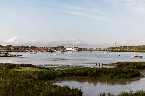 A view of the Tide Mill with the river Deben in the foreground. There are row boats and small fishing boats moored up in the river — Stock Photo, Image
