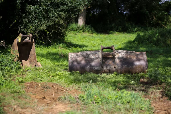 2 excavadoras, cubos de excavadora sentados en una zona cubierta de hierba esperando ser utilizados en la máquina cuando sea necesario —  Fotos de Stock
