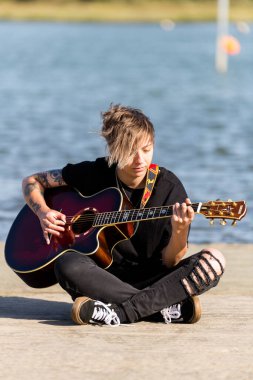 Woodbridge, Suffolk, İngiltere 20 Eylül 2020: 20 gibi bir kadın dışarıda akustik gitar çalıyor ve yoldan geçenler de dinliyor
