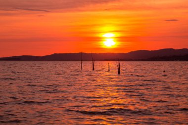 Mavi gökyüzü ve gün batımıyla manzaralı göl manzarası 