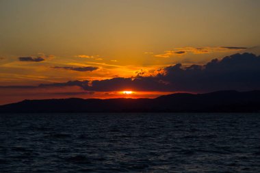 Mavi gökyüzü ve gün batımıyla manzaralı göl manzarası 