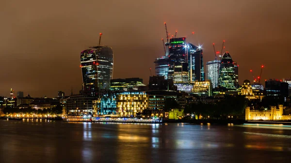 Skyline Londynu z jego słynnych drapaczy chmur i na pierwszym planie Tamiza w nocy — Zdjęcie stockowe