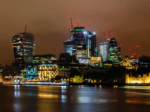 Skyline de Londres con sus famosos rascacielos y en primer plano el Támesis por la noche —  Fotos de Stock