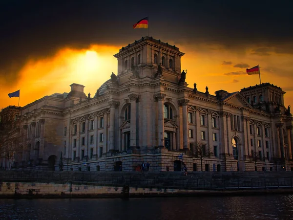 Alman Parlamentosu Reichstag Binası bahar akşamının batımında. Spree Nehri 'nin diğer kıyısından görüntüle.