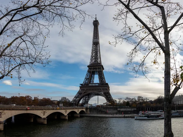 Paris, Fransa - 25 Kasım 2019 - Sonbaharda Paris CItyscape 'i. Gemiler ve tugaylar Seine nehri üzerinde Eyfel kulesiyle arka planda ve dramatik bulutlu gökyüzünde.