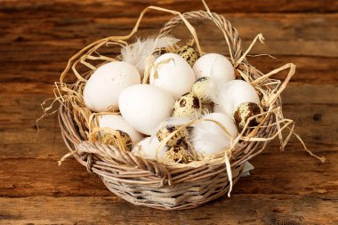 Ahşap arka plan üzerinde sepet içinde tavuk ve bıldırcın yumurtası yığını