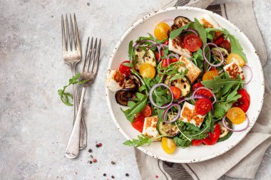 Taze sebze salatası roka, ızgara sebze, şeri domates ve halloumi peyniri. Sağlıklı yiyecek.