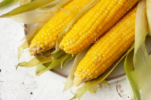 Ears of boiled corn in leaves