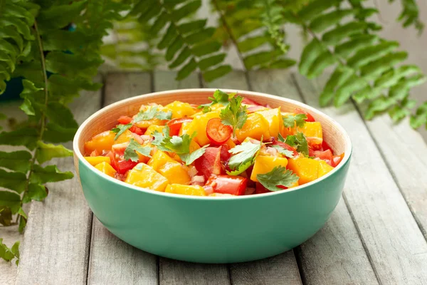 Fresh salad with mango, red pepper, tomatoes and cilantro.
