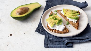 Süzme peynir ve avokadoyla sağlıklı çavdar tostu..