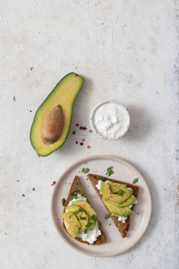 Süzme peynir ve avokado ile sağlıklı çavdar ekmeği.