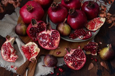 Taze sulu nar - bütün ve kesilmiş, ahşap bir zemin üzerinde yaprakları ile