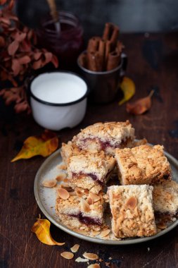 Lezzetli taze turta parçaları ile dolu bir tabak çilek reçeli ve üzeri fındıkla süslenmiş. 