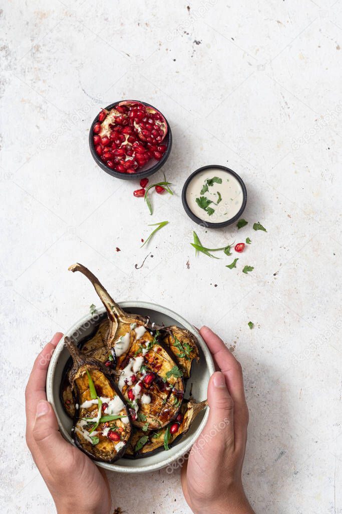 Grilled eggplants with  sauce, herbs and pomegranate