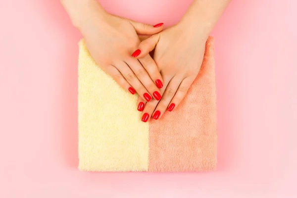 Руки красивой молодой женщины на розовом и желтом полотенце . — стоковое фото