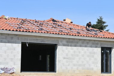 Güneş panelleri için metal altyapı döşeyen işçiler yerleşim yerlerinin çatısına konuşlandırılıyor