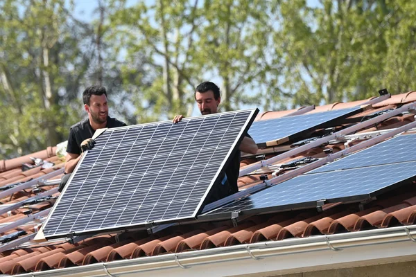 building Workers installing solar panels on metal infrastructure on residential house roof
