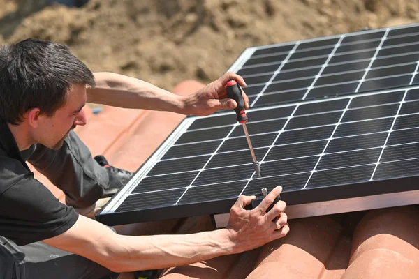 Építőipari Dolgozó Rögzítése Alternatív Energia Fotovoltaikus Napelemek Tetőn Csavarhúzóval — Stock Fotó
