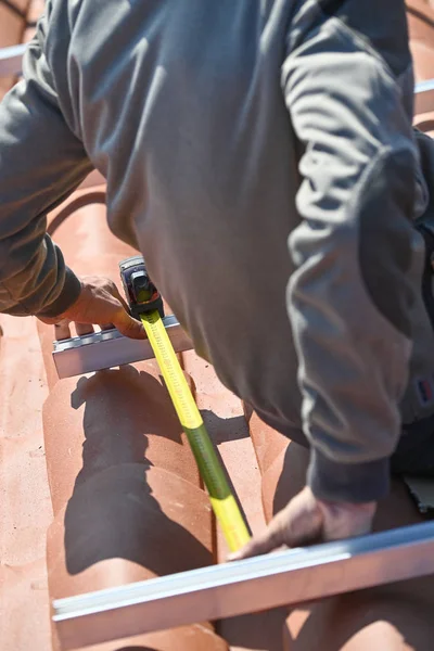 La construcción de trabajadores que midan los elementos estructurales para instalar paneles solares —  Fotos de Stock