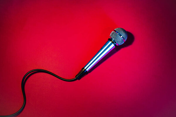 Silver microphone on a red background.