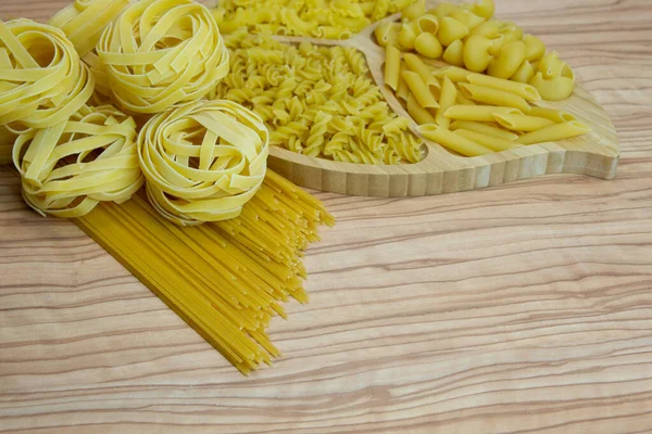 Macarrão ninhos espaguete vieiras linguini penne tagliatelle fusilli espirais . — Fotografia de Stock