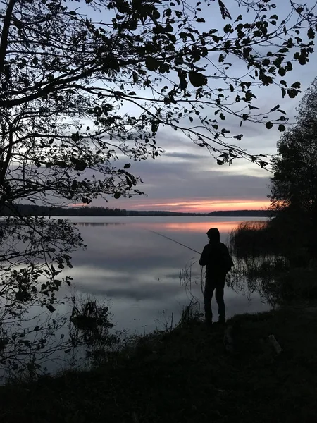 Silhouette of a fisherman at sunset